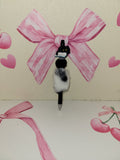 Black and white kitty on a book fluffy pen